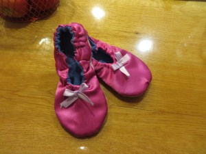 Pink costume satin w/ encased elastic closure and ribbon embellishment.