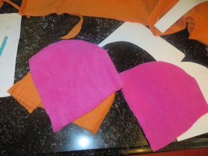Two bonnet pieces cut from pink fleece.
