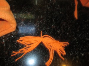 Threads cut and tied for bangs.