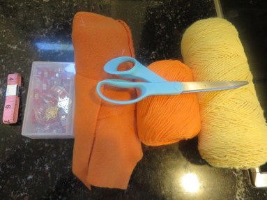Two pieces (to size of your child's head*), matching yarn, yellow yarn, Wonder Clips, measuring tape, scissors.