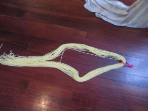 Yarn cut to length, folded in half, with a pontytail holder slipped over the edge and into the middle.